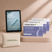 Auf einer hellbraunen Fläche mit rosa-beigem Hintergrund sind eine Tablette mit der Aufschrift „Nature meets Science“, drei Schachteln mit der Aufschrift „Döderlein Female Biotic – 3-Monats-Kur“ sowie ein beiger Beutel mit der Aufschrift „Ooh la la“ angeordnet.
